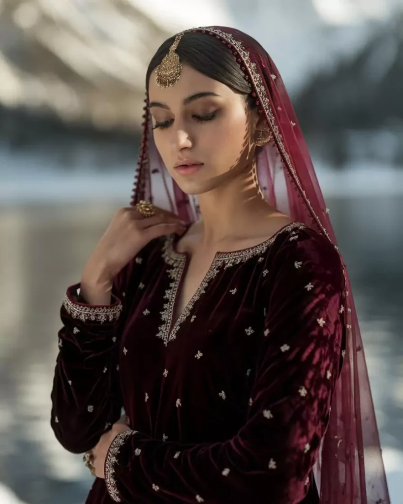 Prompts to Create Beautiful Indian Girls in Diverse Indian Attires AI-generated image of a beautiful Indian girl wearing an ornate maroon Kashmiri pheran with detailed golden embroidery and a matching embellished dupatta, styled with traditional jewelry, capturing the serenity and craftsmanship of Kashmir's iconic attire by AI Artz.