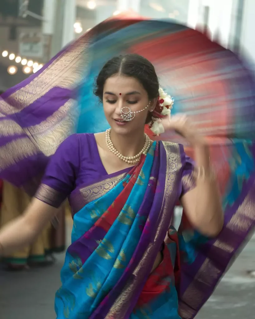 Prompts to Create Beautiful Indian Girls in Diverse Indian Attires AI-generated image of a beautiful Indian girl dancing in a vibrant Nauvari saree from Maharashtra, featuring bold blue, red, and purple colors with gold borders, styled with jasmine flowers and pearl jewelry, capturing the strength and tradition of Maharashtrian culture by AI Artz.