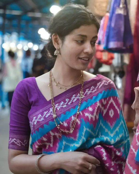 Prompts to Create Beautiful Indian Girls in Diverse Indian Attires AI-generated image of a beautiful Indian woman wearing a vibrant magenta and turquoise Pochampally Ikat saree, adorned with gold jewelry, standing in a bustling traditional market, highlighting the iconic weaving art of Andhra Pradesh and Telangana by AI Artz.