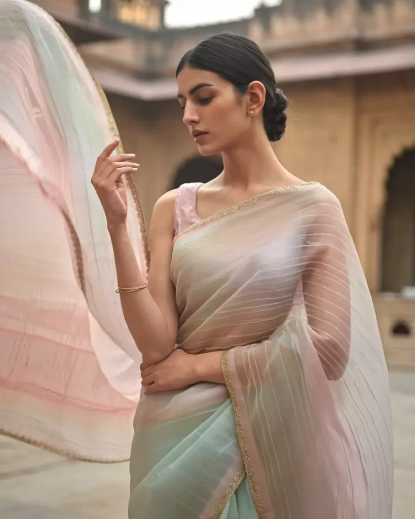 Prompts to Create Beautiful Indian Girls in Diverse Indian Attires AI-generated image of a beautiful Indian girl draped in a pastel-hued Chanderi saree with golden borders, styled simply in a heritage courtyard setting, highlighting the elegance and traditional weaving artistry of Madhya Pradesh's Chanderi and Maheshwari sarees by AI Artz.