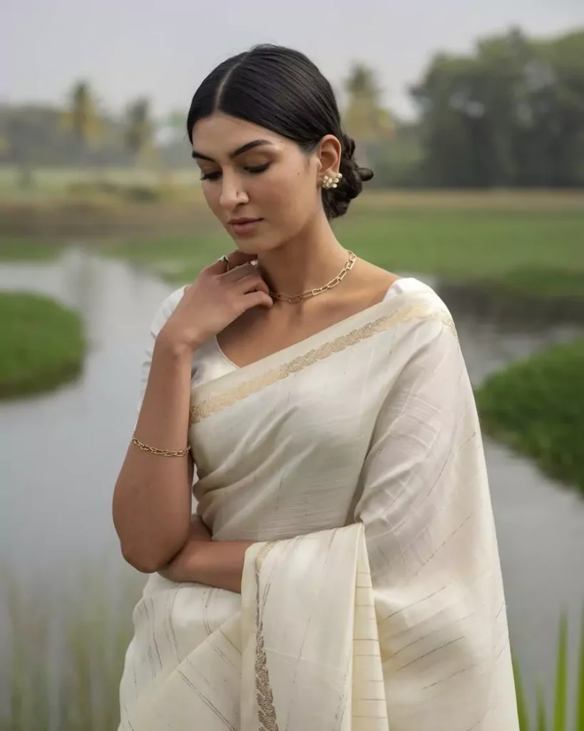Prompts to Create Beautiful Indian Girls in Diverse Indian Attires AI-generated image of a beautiful Indian girl wearing a traditional white and gold Kasavu saree from Kerala, elegantly styled with minimal jewelry, posing by lush green waterside, embodying the serenity and grace of Kerala's cultural heritage by AI Artz.