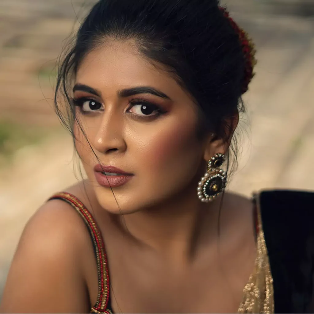Indian Woman wearing a deep black velvet saree with gold embroidered border and traditional statement earrings, styled for a classic festive occasion with natural outdoor lighting, serving as the original image reference for Google Gemini AI photo editing prompts, trending saree transformations, and elegant retro looks for girls by AI Artz