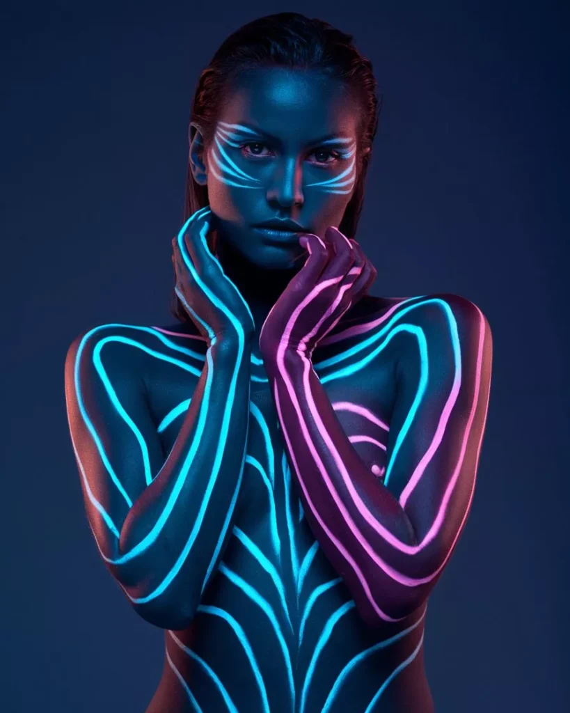 Symmetrical neon body paint with glowing pink and blue organic lines on a model with arms crossed, featuring hyper-realistic skin texture and bioluminescent light effects in a dark studio setting by AI Artz