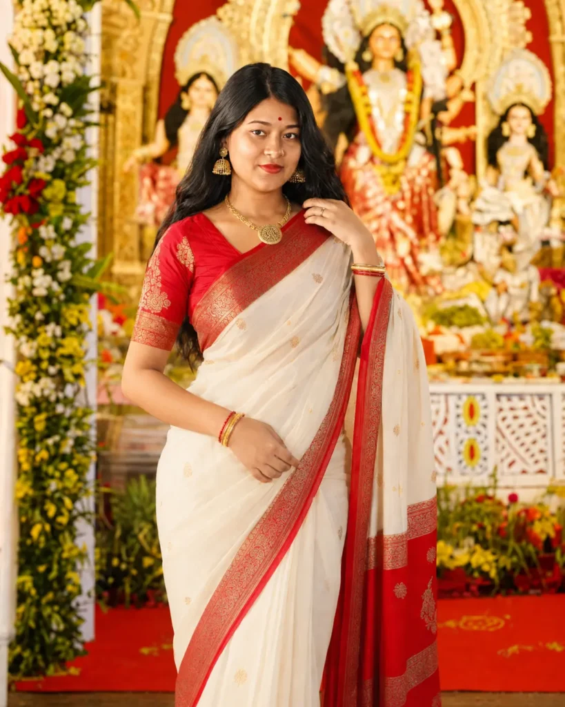 Trisha Roy in a traditional white and red Bengali saree at a Durga Puja pandal, featured in Durga Puja Gemini AI Prompts for realistic festival image generation by Subhra Prakash Mohanty